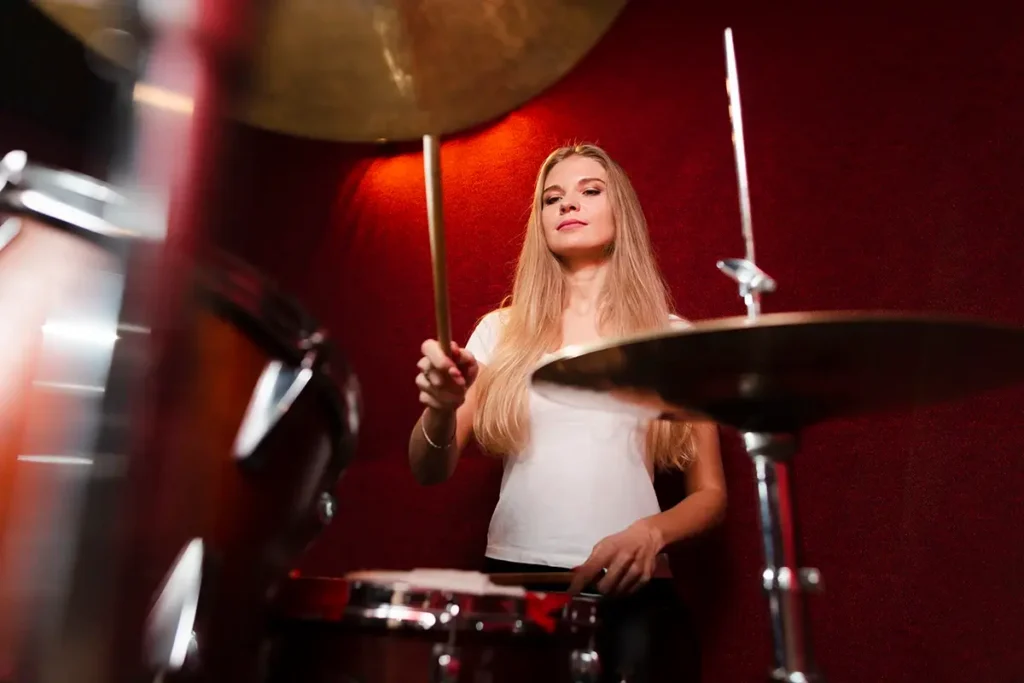 Foto de mujer joven tocando la batería